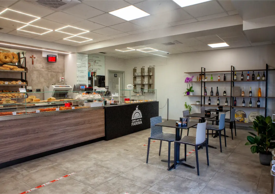 Interno del panificio Fatti con la Farina in Via Messina a Potenza: banco, dolci e tavoli