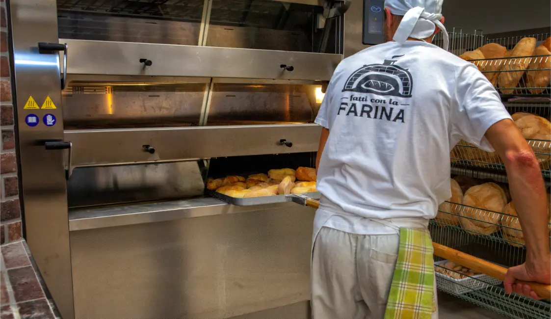 Panettiere di Fatti con la Farina al forno a legna a Potenza mentre inforna il pane